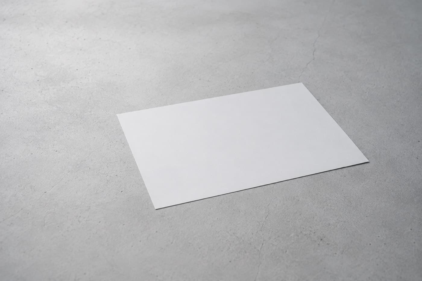 A single blank sheet alone on the same grey surface